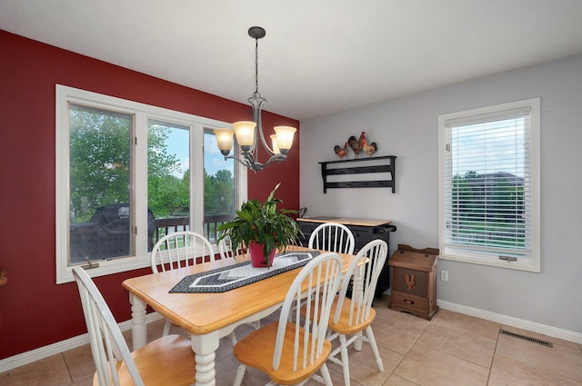 dining area with light tile patterned floors, a notable chandelier, baseboards, and visible vents