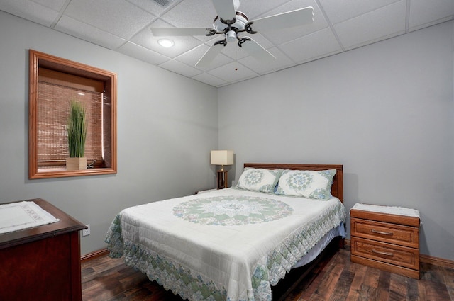 bedroom with a paneled ceiling, ceiling fan, wood finished floors, and baseboards