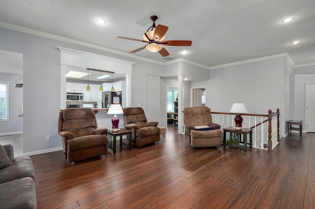 living room featuring dark wood-type flooring, ceiling fan, ornamental molding, and baseboards