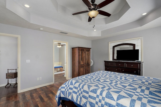 bedroom featuring recessed lighting, a tray ceiling, visible vents, baseboards, and wood finished floors