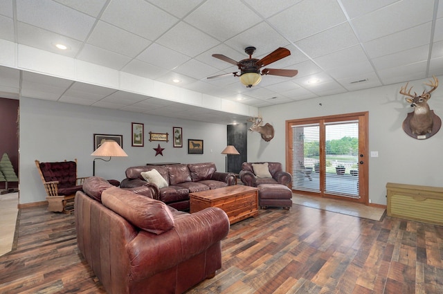 living room featuring wood finished floors, a ceiling fan, and a drop ceiling