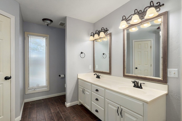bathroom featuring a sink, wood finished floors, and baseboards
