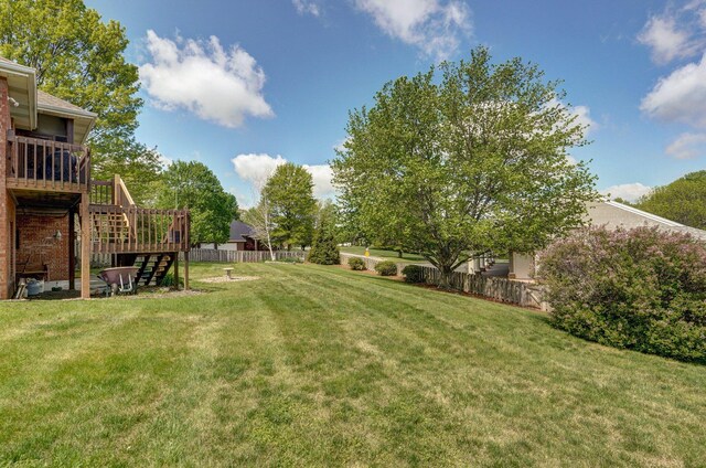 view of yard with stairs, a wooden deck, and fence