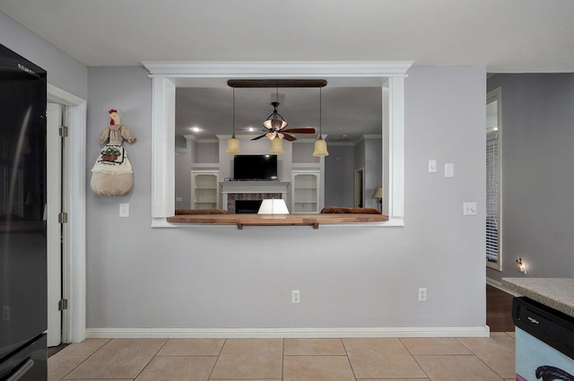 kitchen featuring tile patterned flooring, decorative light fixtures, a fireplace, a ceiling fan, and dishwashing machine