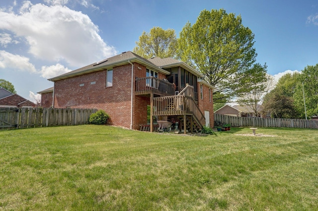 back of property featuring a lawn, brick siding, a fenced backyard, and stairs