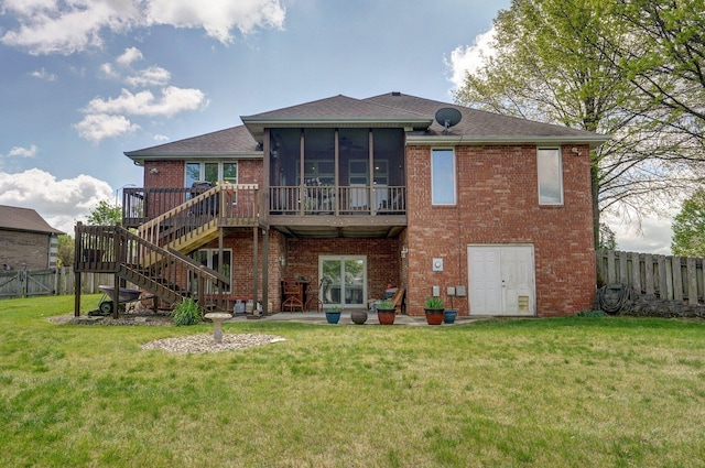 back of house with brick siding, a fenced backyard, a yard, and a sunroom