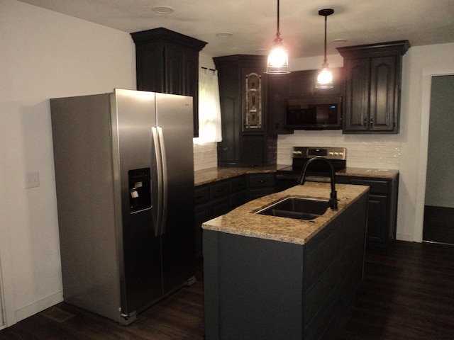 kitchen featuring a sink, appliances with stainless steel finishes, decorative backsplash, and dark wood-style flooring