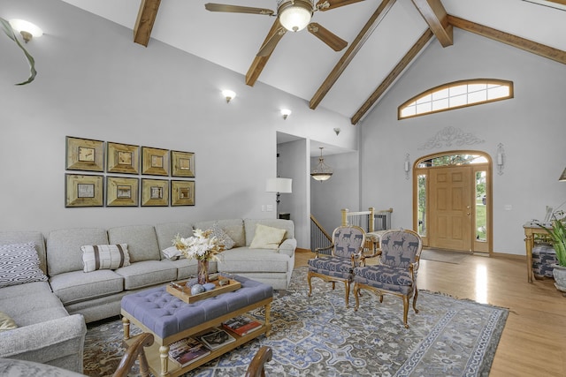 living room with high vaulted ceiling, beamed ceiling, a ceiling fan, and light wood-style flooring