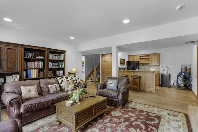 living room with recessed lighting, stairs, and light wood-style floors