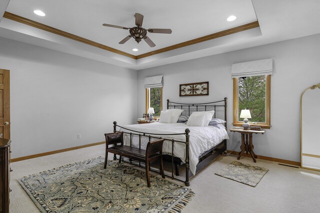 bedroom with baseboards, a raised ceiling, multiple windows, and carpet flooring