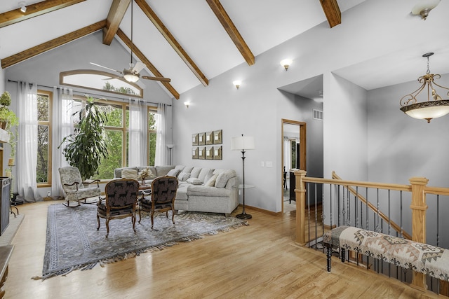 living room with visible vents, wood finished floors, ceiling fan, beam ceiling, and high vaulted ceiling