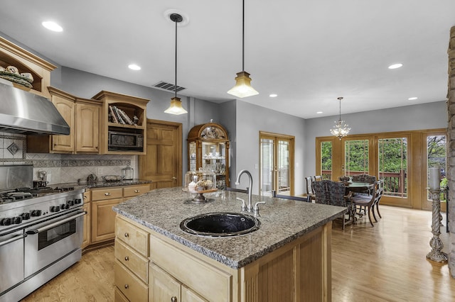 kitchen featuring a sink, light wood-style floors, black microwave, visible vents, and double oven range