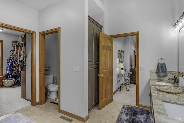 bathroom featuring visible vents, baseboards, tile patterned flooring, and a sink