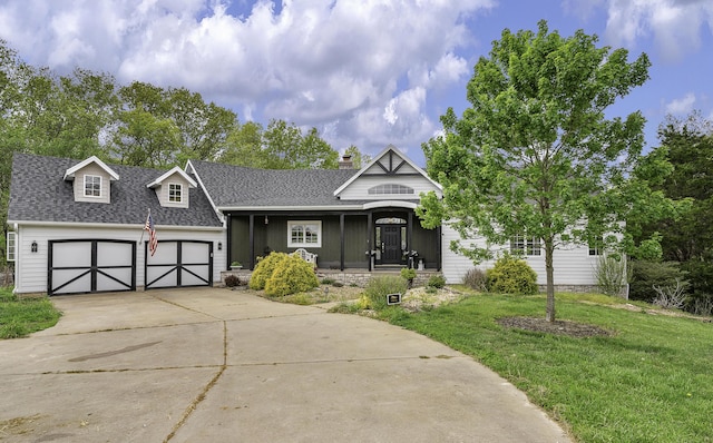 view of front facade featuring a shingled roof, a front lawn, and concrete driveway