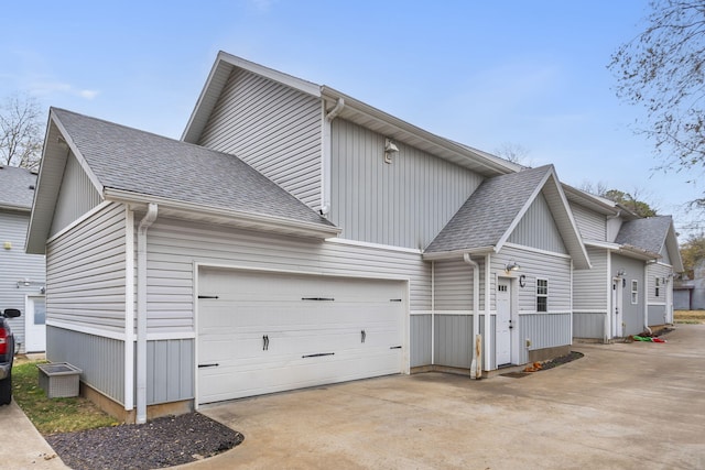 view of property exterior featuring concrete driveway, an attached garage, and roof with shingles