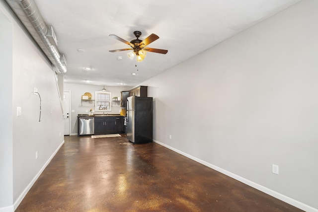 unfurnished living room featuring a sink, finished concrete floors, a ceiling fan, and baseboards