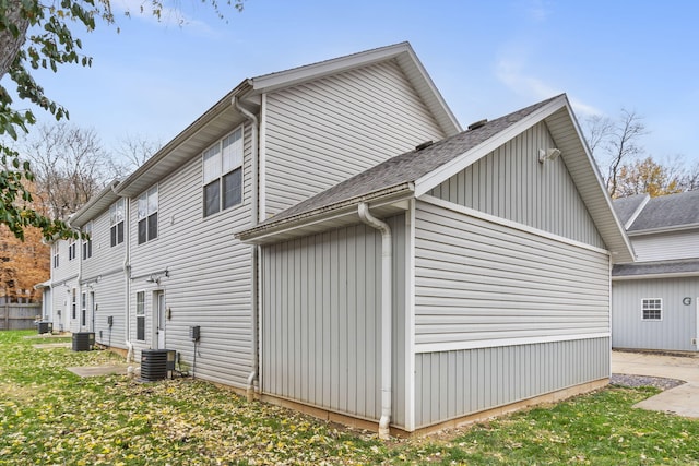 view of home's exterior featuring cooling unit and a shingled roof