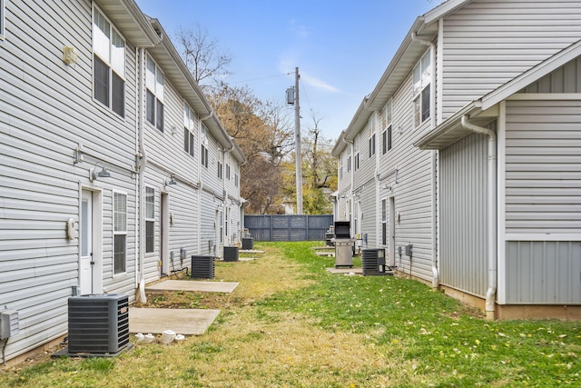view of yard with fence and central AC unit