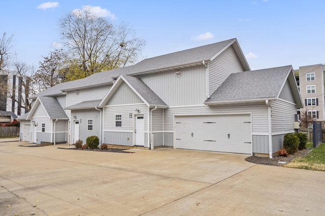 view of front facade with concrete driveway, a garage, and roof with shingles