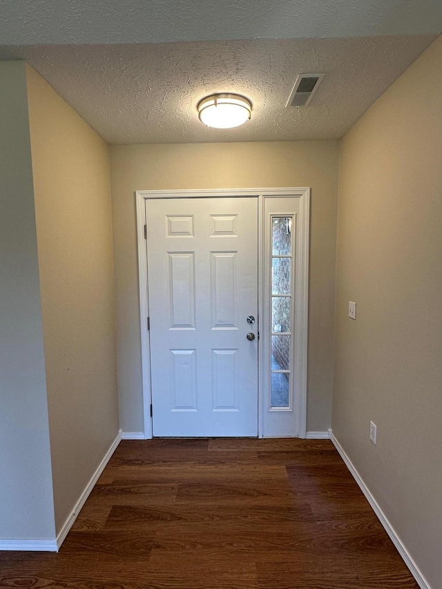 entrance foyer featuring visible vents, wood finished floors, and baseboards