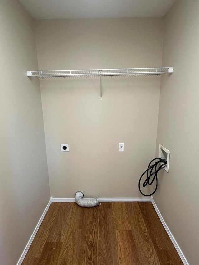 clothes washing area with laundry area, electric dryer hookup, hookup for a washing machine, baseboards, and wood finished floors