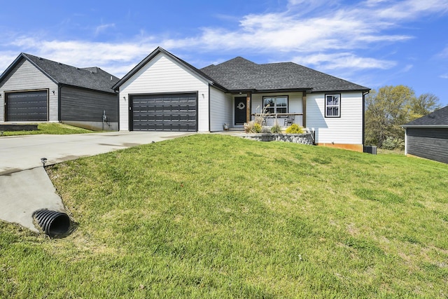 view of front of home featuring covered porch, a shingled roof, a garage, a front yard, and concrete driveway