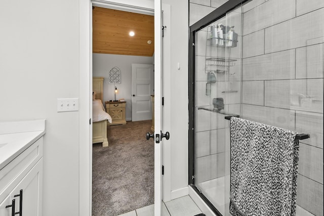 bathroom with baseboards, a shower stall, and vanity