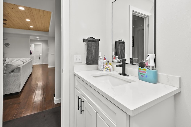 bathroom with wood ceiling, wood finished floors, vanity, and recessed lighting