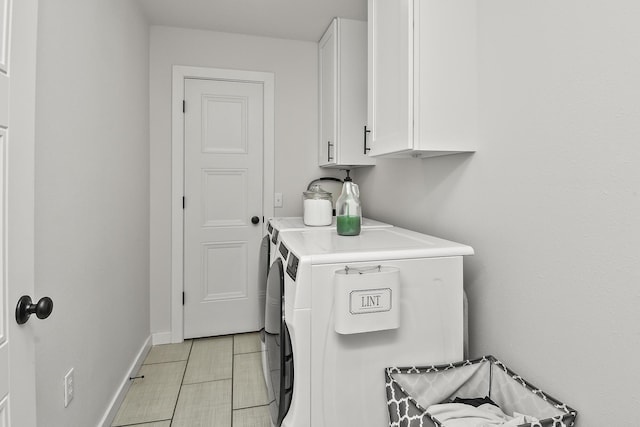 washroom featuring cabinet space, washing machine and clothes dryer, and baseboards