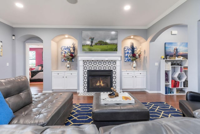living area with ornamental molding, dark wood-style floors, and arched walkways