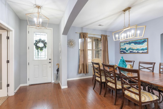 dining area with a healthy amount of sunlight, baseboards, arched walkways, and a notable chandelier
