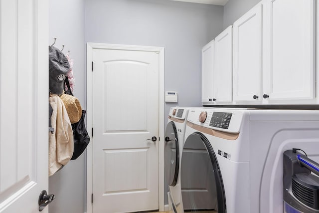 washroom featuring cabinet space and washing machine and clothes dryer