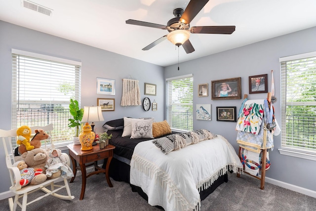 carpeted bedroom featuring visible vents, baseboards, a ceiling fan, and multiple windows