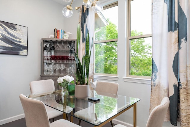 dining space with an inviting chandelier, plenty of natural light, and baseboards