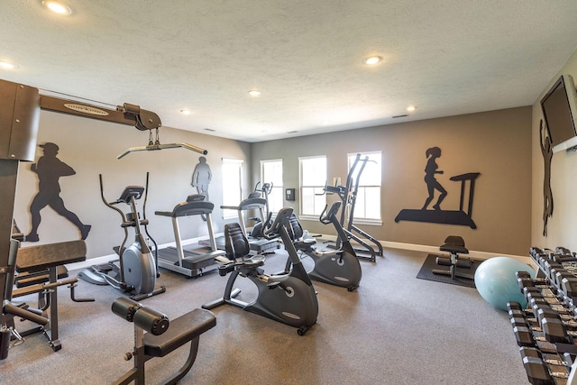 workout area featuring baseboards, recessed lighting, and a textured ceiling