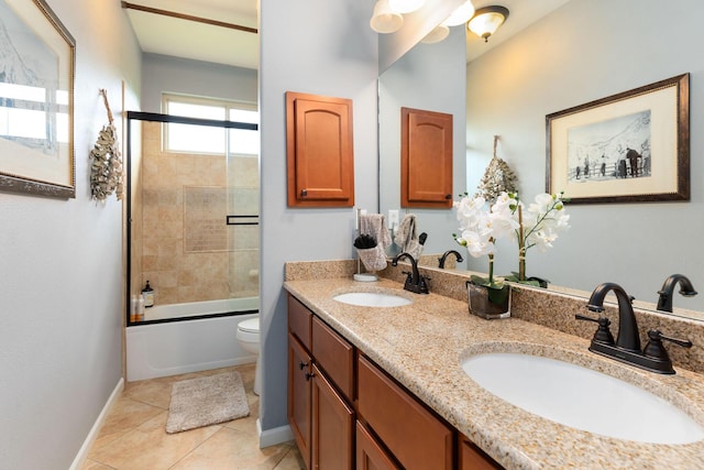 full bath with baseboards, shower / bath combination with glass door, double vanity, and a sink