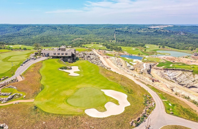 bird's eye view with a water view, golf course view, and a wooded view