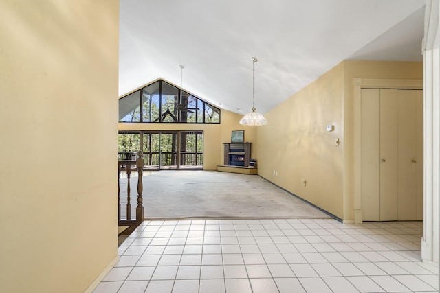 unfurnished living room featuring a fireplace with raised hearth, high vaulted ceiling, light colored carpet, and baseboards
