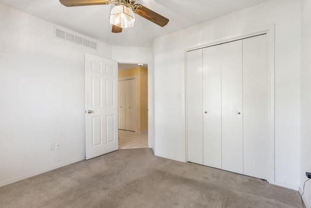 unfurnished bedroom featuring a closet, visible vents, ceiling fan, and carpet