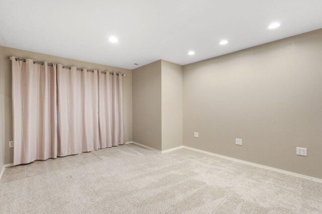 empty room featuring baseboards, recessed lighting, and light carpet