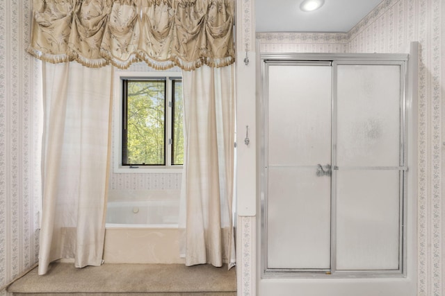 full bath featuring combined bath / shower with glass door and wallpapered walls
