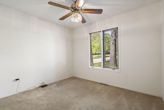carpeted spare room with ceiling fan and plenty of natural light