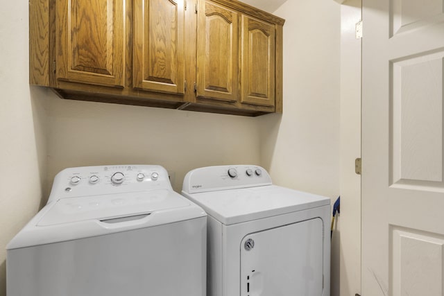 clothes washing area with cabinet space and washing machine and dryer