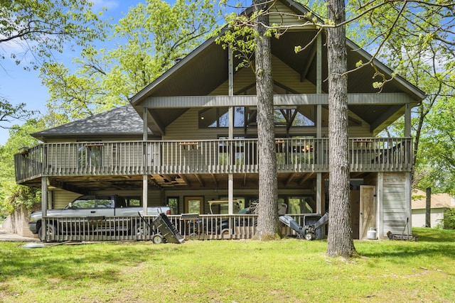 back of property featuring a lawn, a wooden deck, and roof with shingles