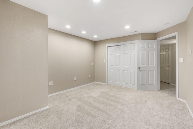 unfurnished bedroom featuring recessed lighting, a closet, carpet, baseboards, and visible vents