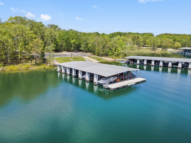 view of dock with a water view and a forest view