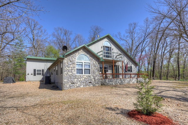13098 Cody Ln, Diamond, MO 64840 - rear view of house with cooling unit, board and batten siding, stone siding, and a porch