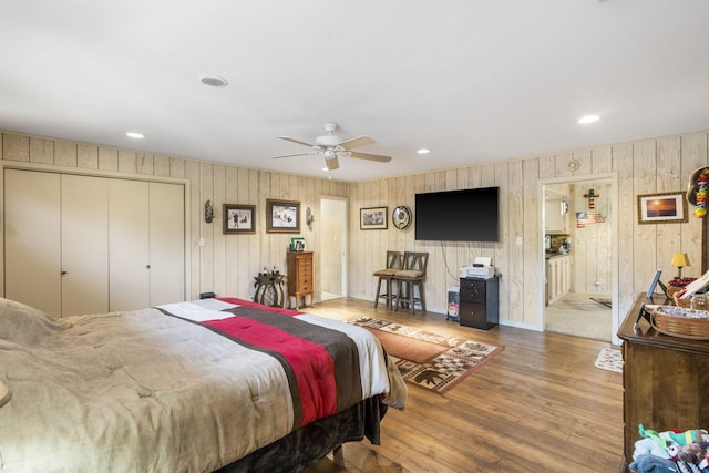 bedroom featuring wooden walls, recessed lighting, and wood finished floors