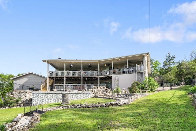 rear view of house featuring fence, a ceiling fan, and a yard