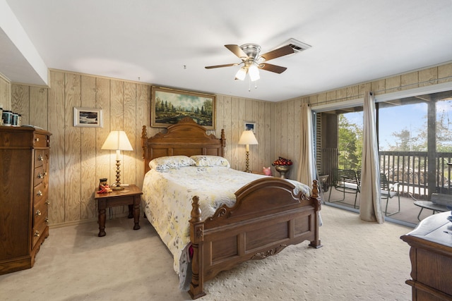 bedroom with wood walls, baseboards, access to outside, and light carpet